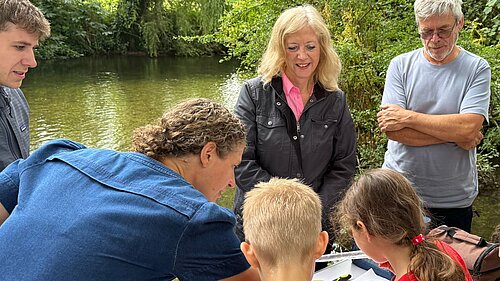 Liz Jarvis MP with children testing a sample from the River Itchen