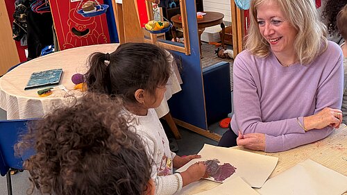 Liz Jarvis MP sat with 2 primary school students in a school